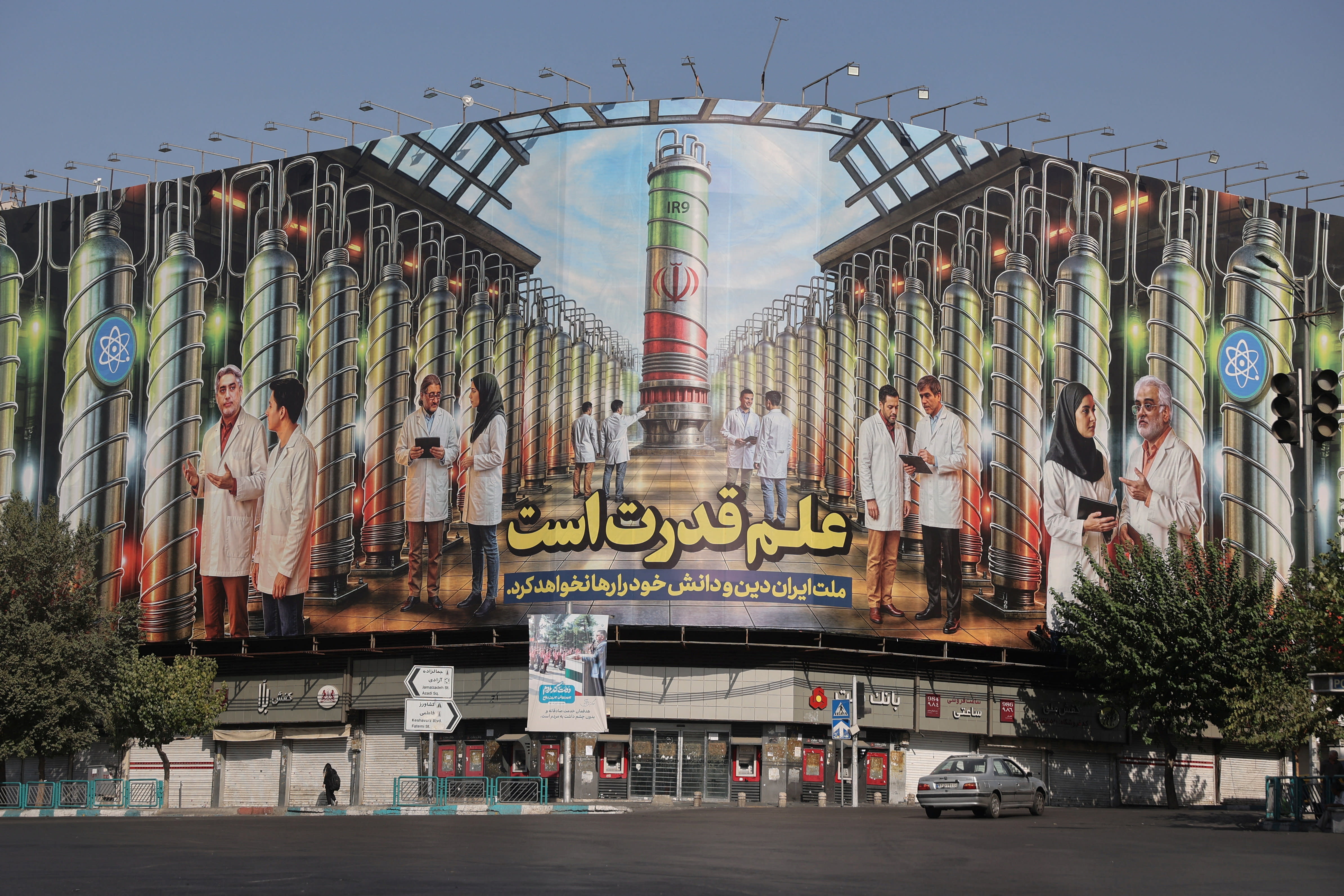 A billboard with Iranian centrifuges illustrations and portraits of nuclear scientists killed in Israeli strikes is displayed on a street in Tehran, Iran August 29, 2025 (credit: MAJID ASGARIPOUR/WANA