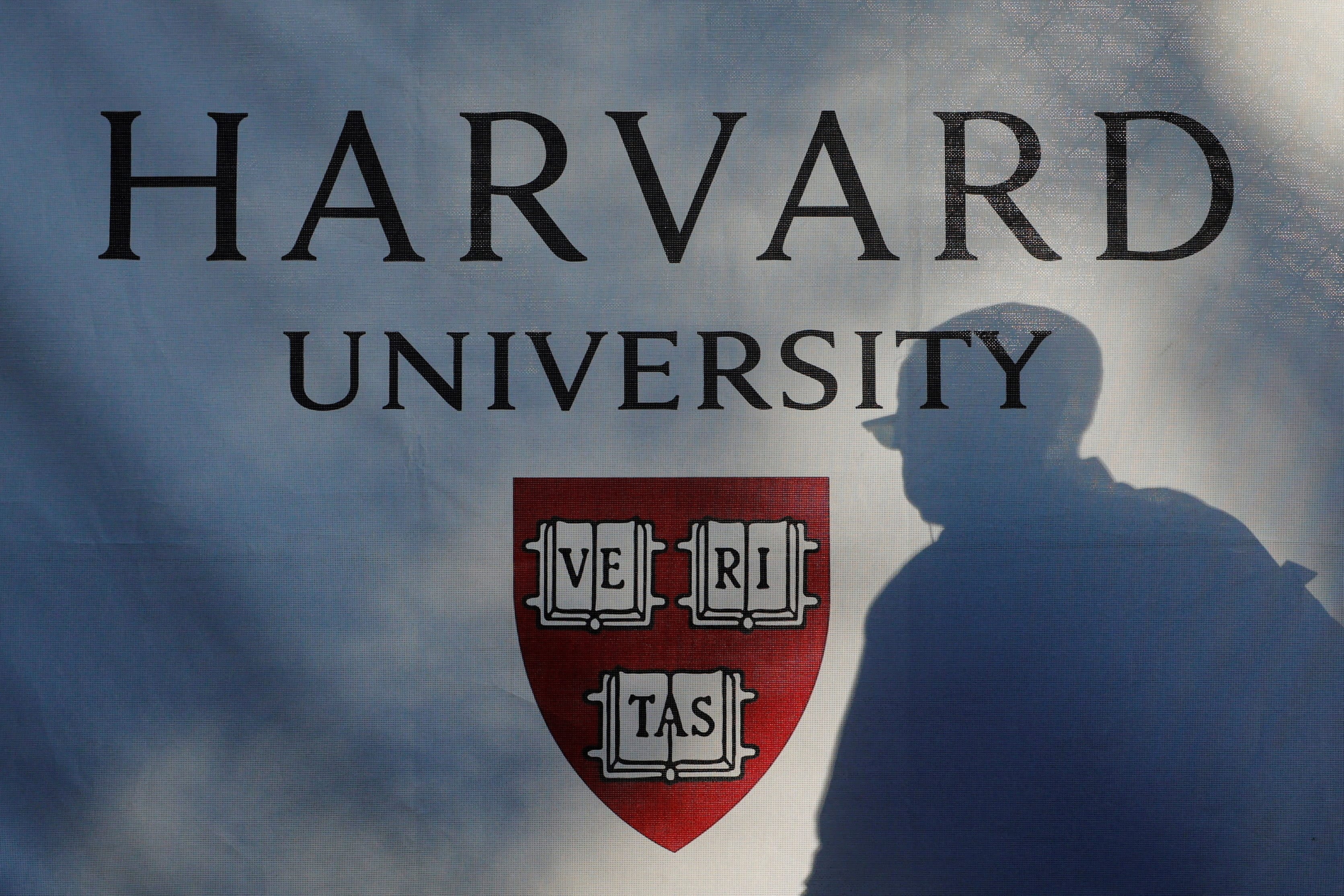 A pedestrian casts a shadow on a Harvard University sign after US President Donald Trump said that his administration was close to a deal with Harvard University, in Cambridge, Massachusetts, US, September 30, 2025.