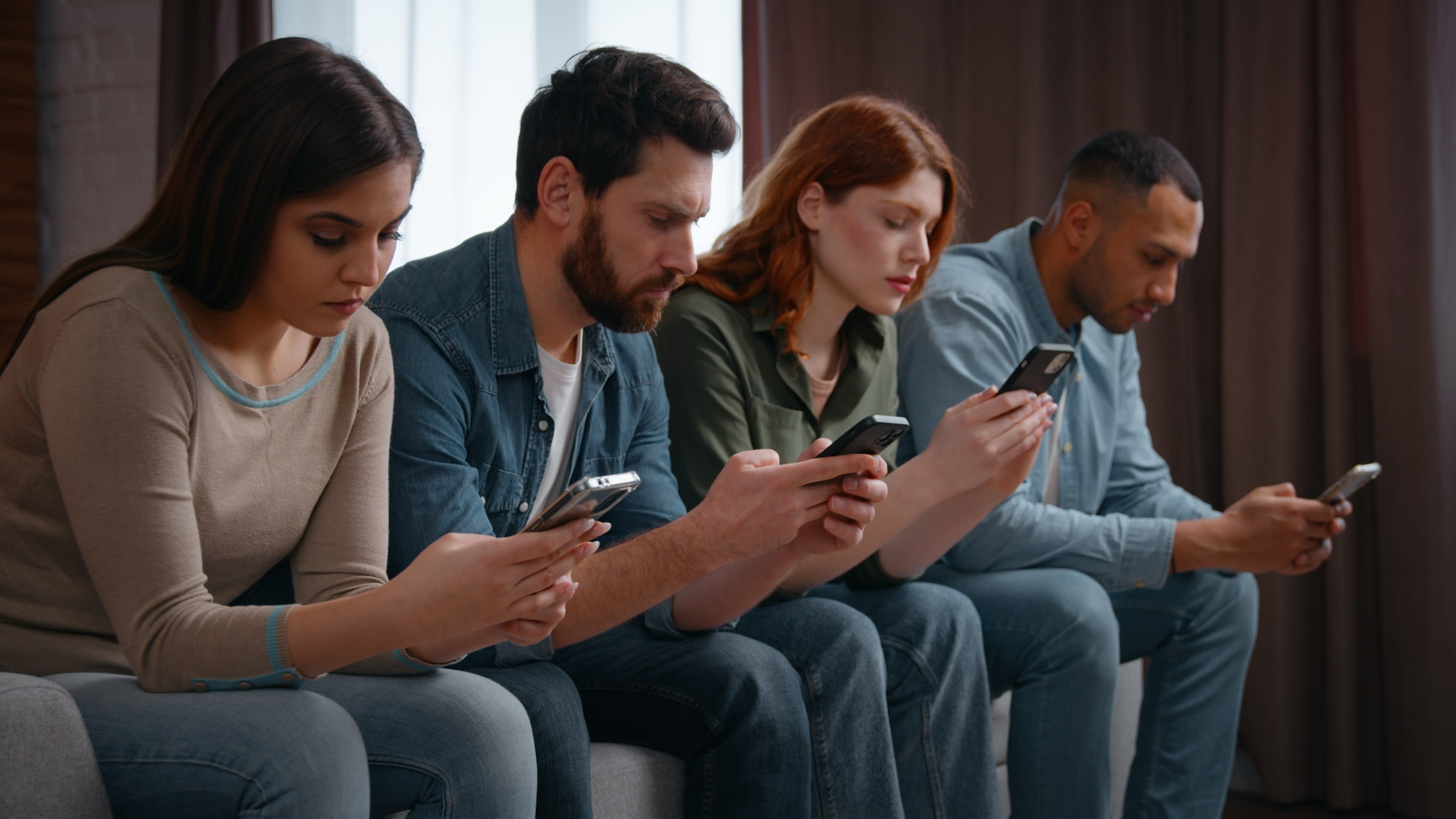 An illustration of four people focusing on their mobile phone screens.