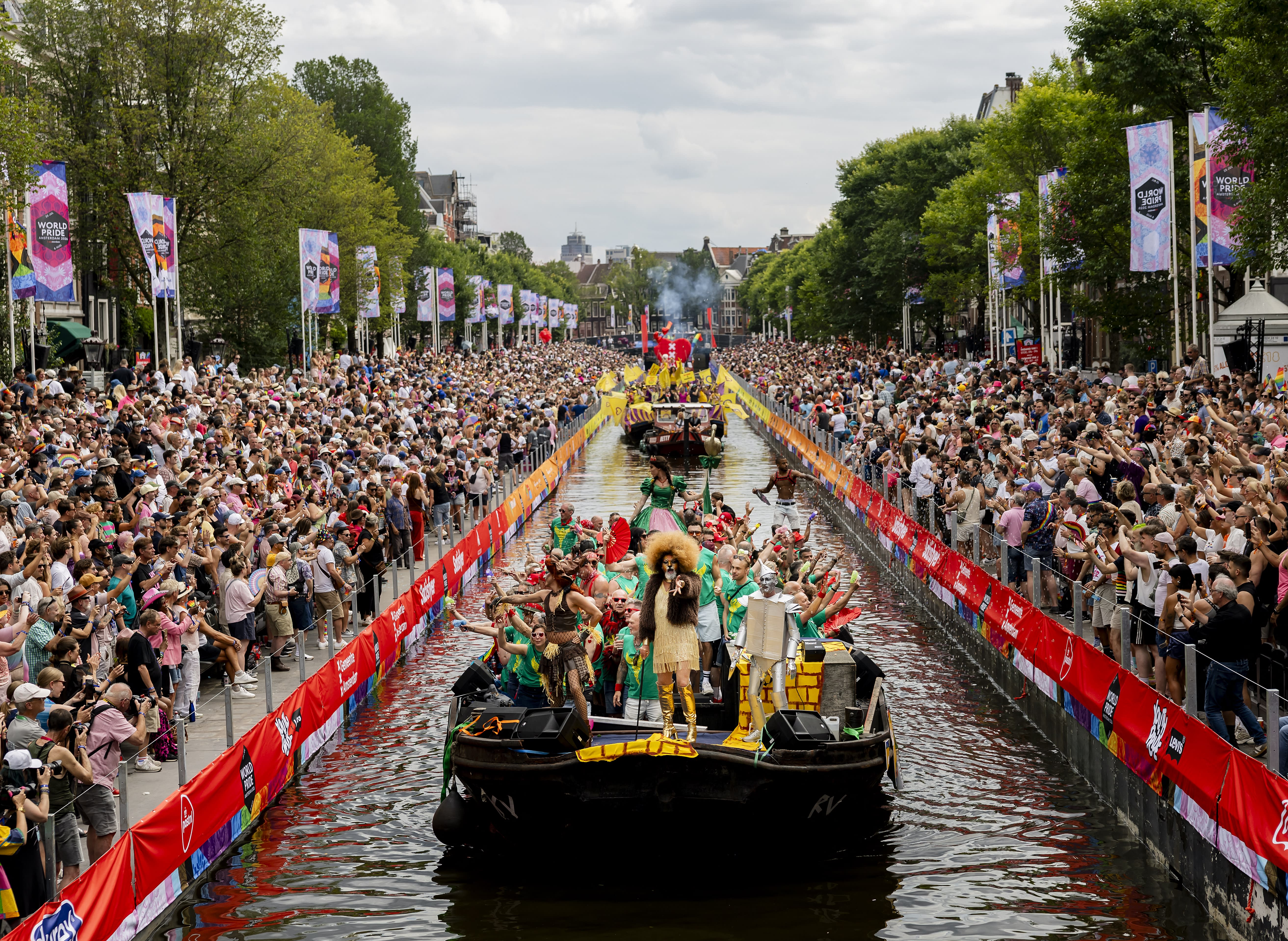 Participants on boats pass next to spectators on a canal as they take part in the Canal Parade of the Pride celebrations in Amsterdam on August 1, 2026; illustrative.