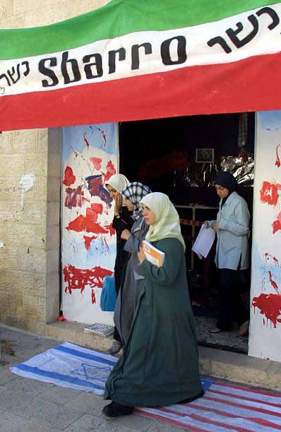 Women walk out of the Al-Najah University exhibition of the 2001 Sbarro bombing.