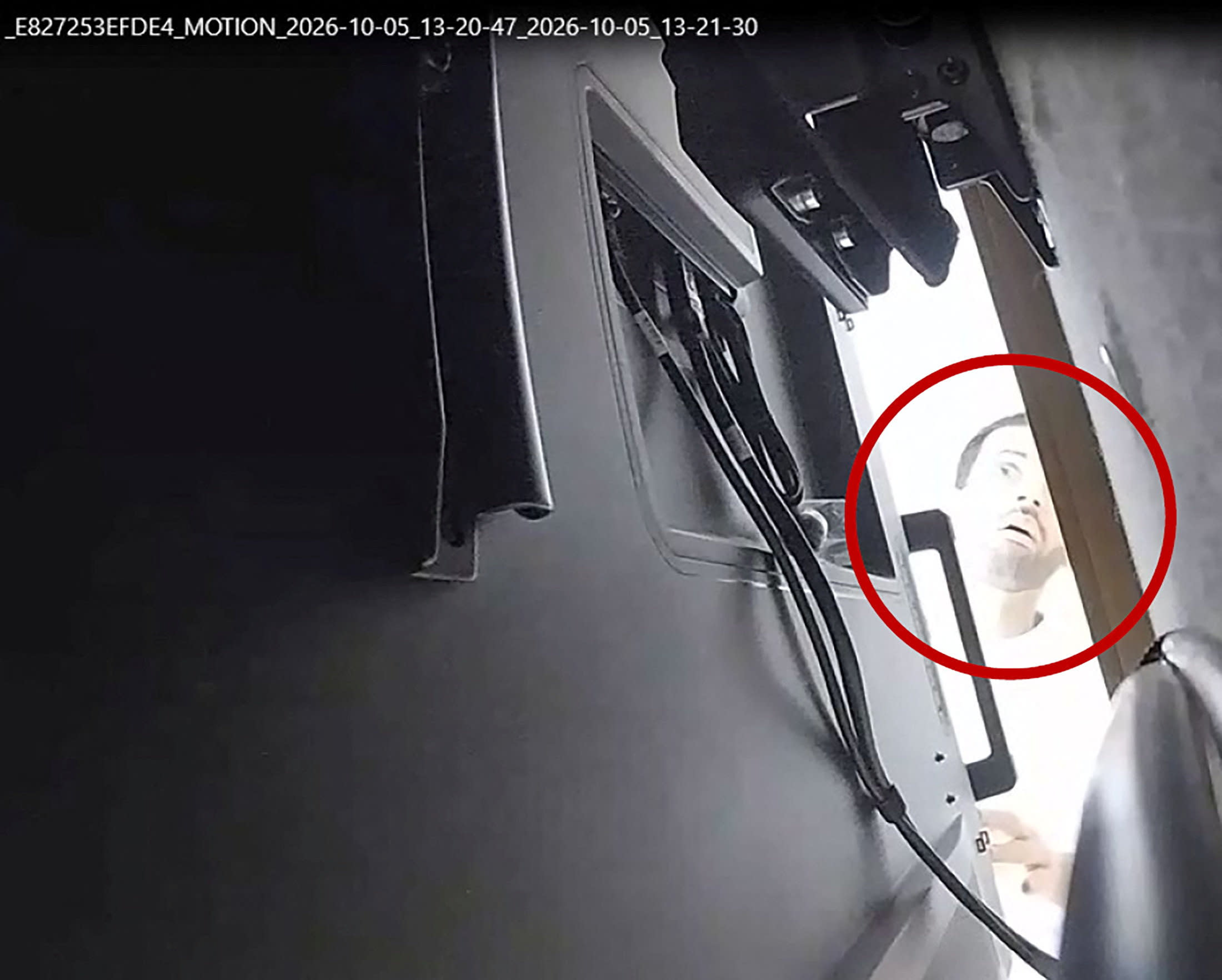 A man described as Abdulrahman Alfozan, a Saudi national employed as an OpenAI engineer, looks behind a television where a recording device had been placed at a conference room in OpenAI offices, in a still image from surveillance video included in a charging document. October 5, 2026.