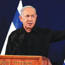  PRIME MINISTER Benjamin Netanyahu holds a news conference in Tel Aviv, last Saturday night. Replacing a suit, white shirt, and tie with a black open-necked shirt is a political act, meant to convey a message, according to the writer. 