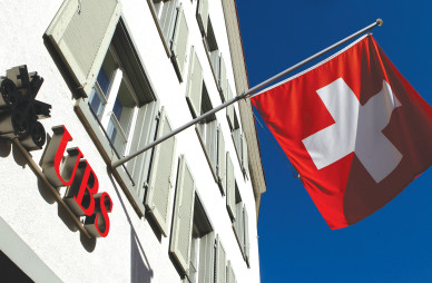  SWITZERLAND’S national flag is seen beside the logo of Swiss bank UBS, in front of a branch office in the town of Riehen, near Basel. 