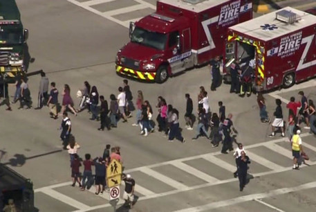 Students are evacuated from Marjory Stoneman Douglas High School during a shooting incident in Parkland, Florida, February 14 
