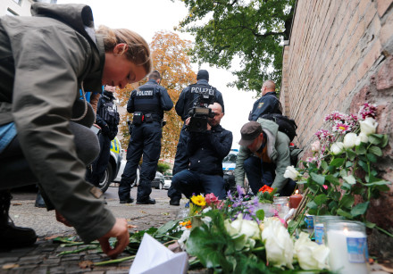 People lay flowers outside the synagogue in Halle, Germany October 10, 2019, after two people were k