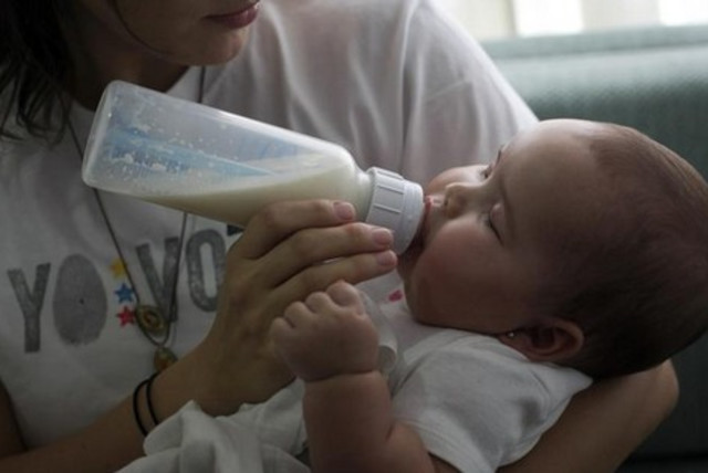 baby drinking from bottle 521 (credit: Reuters)