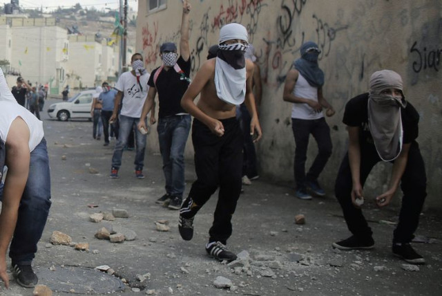 Palestinian youths hurl stones during clashes with Israeli police in the East Jerusalem neighborhood of Wadi Joz, September 7. (credit: AMMAR AWAD / REUTERS)