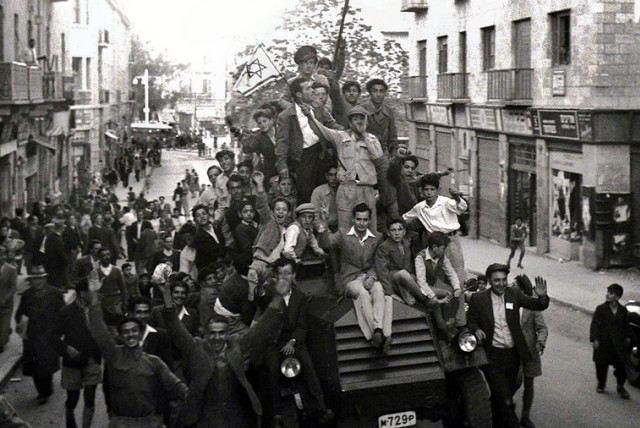 Jews crowd onto a British army armoured car as they celebrate in downtown Jerusalem the morning after the United Nations voted on November 29, 1947 to partition Palestine which paved the way for the creation of the State of Israel on May 15, 1948.  (credit: REUTERS)