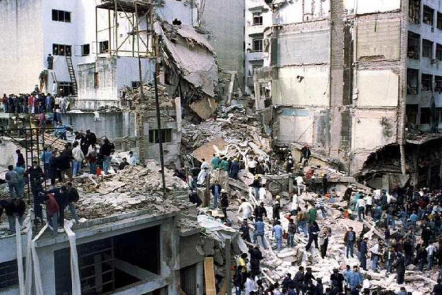 Rescue workers search for survivors and victims in the rubble left after a powerful car bomb destroyed the Buenos Aires headquarters of the Argentine Israeli Mutual Association (AMIA), in this July 18, 1994 file photo (credit: REUTERS)