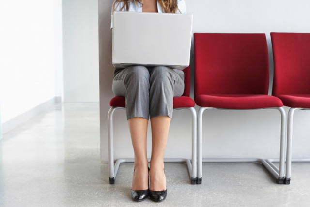 Woman using laptop in office corridor  (credit: ING IMAGE/ASAP)