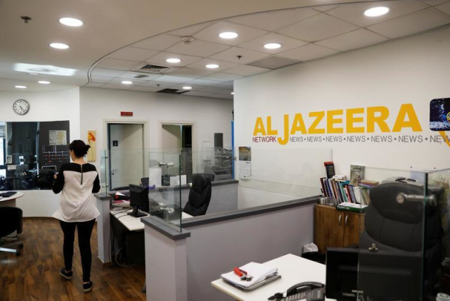 An employee walks inside an office of Qatar-based Al-Jazeera network in Jerusalem June 13, 2017.  (credit: REUTERS)