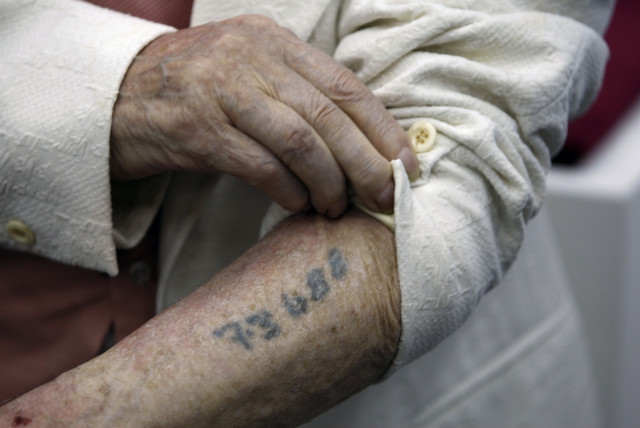 Polish-born Holocaust survivor Meyer Hack shows his prisoner number tattooed on his arm during a news conference at the Yad Vashem Holocaust Museum in Jerusalem June 15, 2009. (credit: REUTERS)