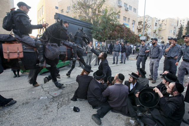 Haredi men protest outside the draft office in Jerusalem on November 28. (credit: MARC ISRAEL SELLEM)