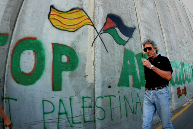 FILE PHOTO: British rock star Roger Waters walks along the Israeli barrier in the West Bank city of Bethlehem (credit: REUTERS/AHMAD MEZHIR/FILE PHOTO)