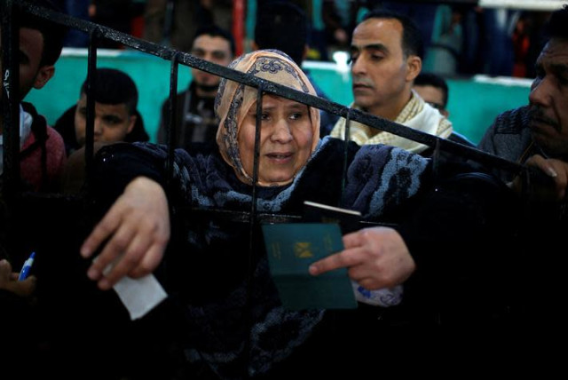 A woman waits for a travel permit to cross into Egypt through the Rafah border crossing after it was opened by Egyptian authorities for humanitarian cases, in the southern Gaza Strip February 21, 2018. REUTERS/Mohammed Salem (credit: REUTERS/MOHAMMED SALEM)