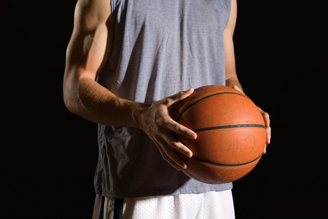 Man holding a basketball (credit: INGIMAGE)