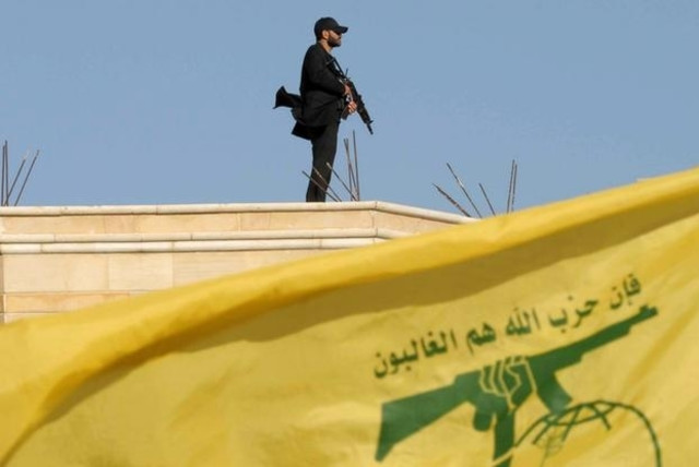 A Hezbollah member carries his weapon on top of a building on May 25, 2016. (credit: HASSAN ABDALLAH / REUTERS)