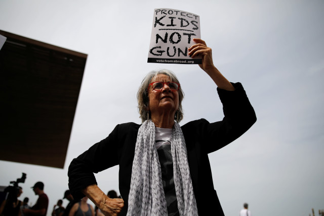 A woman takes part in a protest in front of the US Embassy, calling for enhanced gun control in the US, in Tel Aviv, Israel, March 23, 2018. (credit: REUTERS/CORINNA KERN)