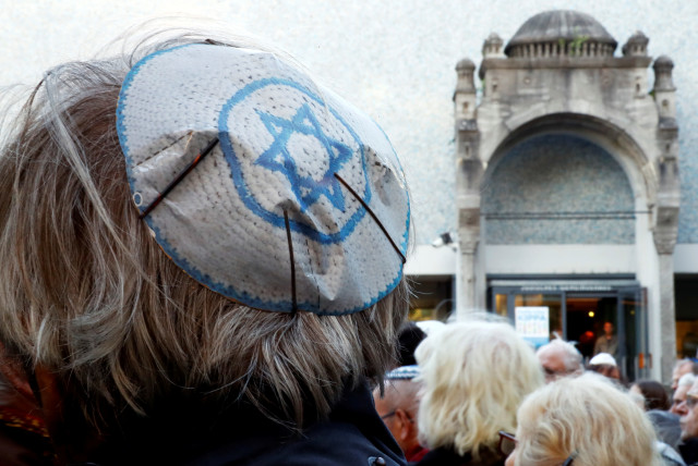 Personas llevan kippas mientras asisten a una manifestación frente a una sinagoga judía, para denunciar un ataque antisemita contra un joven que llevaba una kippa en la capital a principios de este mes, en Berlín, Alemania, 25 de abril de 2018. (crédito: FABRIZIO BENSCH / REUTERS)
