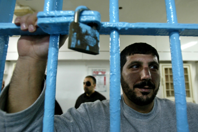 A Palestinian prisoner, convicted of security offences against Israel, looks out of his cell at Nitzan jail (credit: REUTERS/NIR ELIAS)