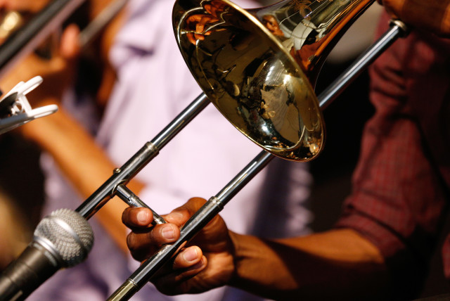 A musician plays a trombone during the first day of the New Orleans Jazz and Heritage Festival in New Orleans, Louisiana April 25, 2014. (credit: JONATHAN BACHMAN/REUTERS)