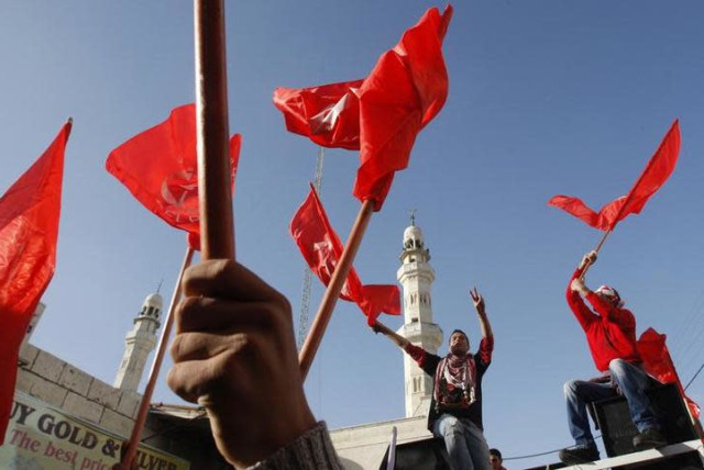 Palestinians take part in a rally organized by the Popular Front for the Liberation of Palestine (PFLP) to celebrate the 43rd anniversary of its founding in the West Bank city of Ramallah December 18, 2010 (photo credit: REUTERS/MOHAMAD TOROKMAN)