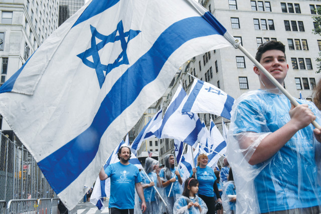 Participants carry Israeli flags at the 'Celebrate Israel'' parade along Fifth Avenue in New York City in 2017 (credit: STEPHANIE KEITH/REUTERS)