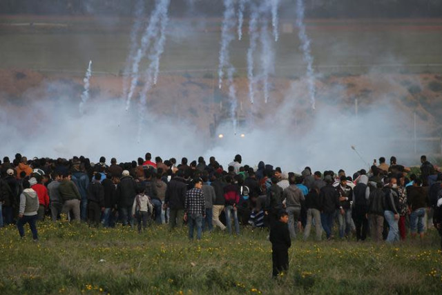 Tear gas canisters are fired by Israeli troops toward Palestinians during a protest at the Israel-Gaza border fence, in the southern Gaza Strip February 22, 2019 (photo credit: REUTERS/IBRAHEEM ABU MUSTAFA)