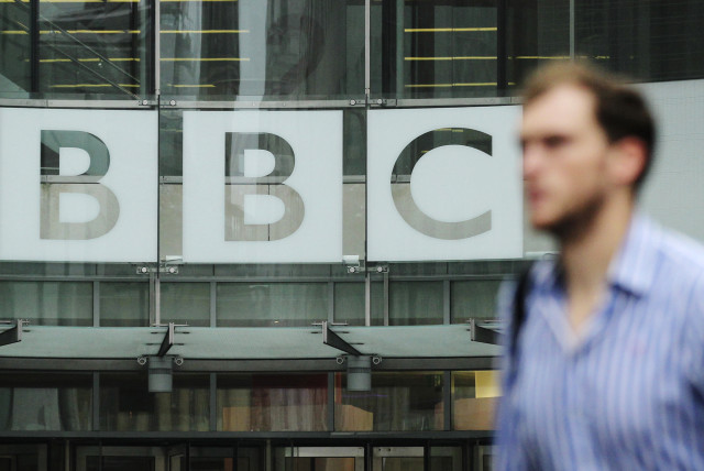 A pedestrian walks past a BBC logo at Broadcasting House in central London (credit: OLIVIA HARRIS/ REUTERS)
