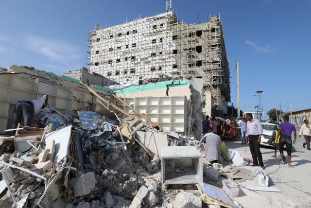 A general view shows people at the scene of a suicide car explosion at a check point near Somali Parliament building in Mogadishu, Somalia June 15, 2019 (credit: FEISAL OMAR/REUTERS)