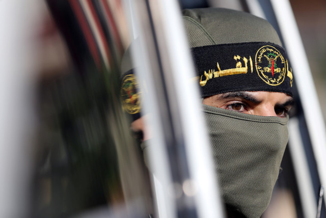 A Palestinian Islamic Jihad militant looks out of a vehicle during a military show marking the 32nd anniversary of the organisation's founding, in the central Gaza Strip October 3, 2019 (credit: REUTERS/IBRAHEEM ABU MUSTAFA)