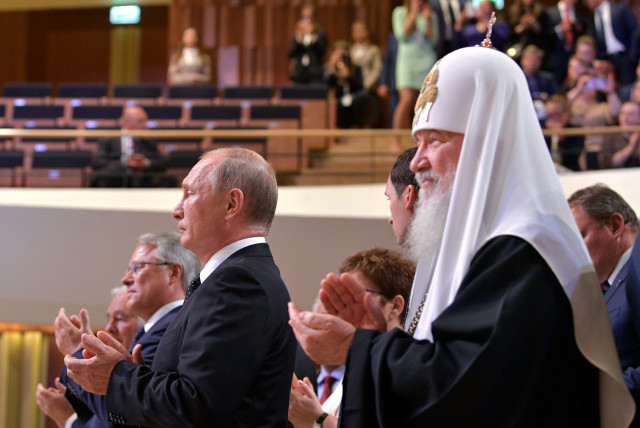 Russian President Putin and Patriarch Kirill applaud during the inaugural ceremony of Moscow Mayor Sergei Sobyanin at the Zaryadye Concert Hall in Moscow (credit: REUTERS)