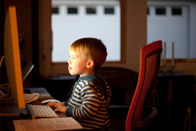 A child sits at the computer (credit: FLICKR)