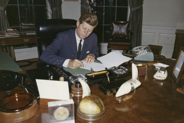 President John F. Kennedy signs a proclamation for the interdiction of the delivery of offensive weapons to Cuba during the Cuban missile crisis, at the White House in Washington in this handout photograph taken on October 23, 1962 (credit: REUTERS/CECIL STOUGHTON/THE WHITE HOUSE/JOHN F. KENNEDY PRESIDENTIAL LIBRARY)