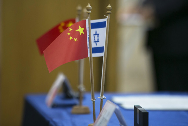Chinese and Israeli flags are seen on a table during a signing ceremony in Tel Aviv, 2014 (credit: BAZ RATNER/REUTERS)