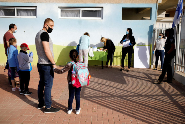 FILE PHOTO: Parents wait with their children to enter their elementary school in Sderot as it reopens following the ease of restrictions preventing the spread of the coronavirus disease (COVID-19) in Israel May 3, 2020 (credit: REUTERS/AMIR COHEN/FILE PHOTO)