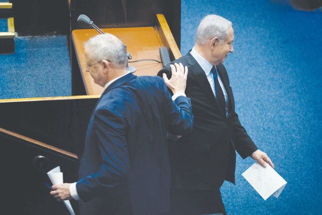 PRIME MINISTER Benjamin Netanyahu and Blue and White Party leader Benny Gantz pass each other in the Knesset last year. (credit: YONATAN SINDEL/FLASH90)