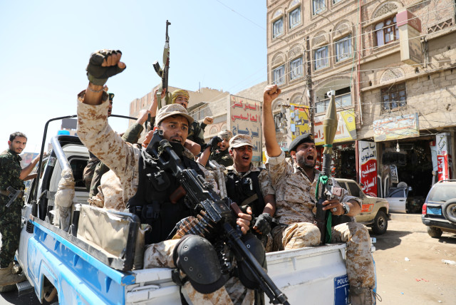 Houthi troops ride on the back of a police patrol truck after participating in a Houthi gathering in Sanaa, Yemen (credit: KHALED ABDULLAH/ REUTERS)