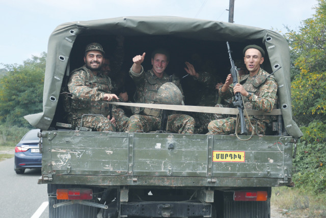 ARMENIAN SOLDIERS ride in the back of a truck in the breakaway region of Nagorno Karabakh last week. The Caucasus region experienced several rounds of conflict after the collapse of the Soviet Union, and the conflict between Azerbaijan and Armenia is one of the most notable disputes. (credit: VAHRAM BAGHDASARYAN/REUTERS)