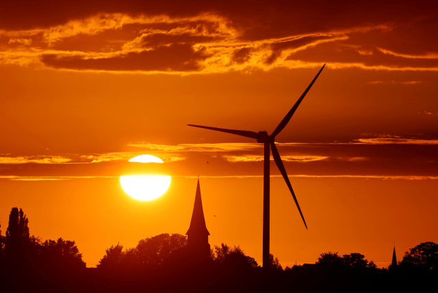 A power-generating windmill turbine is pictured during sunset at a renewable energy park in Ecoust-Saint-Mein, France (photo credit: PASCAL ROSSIGNOL/REUTERS)