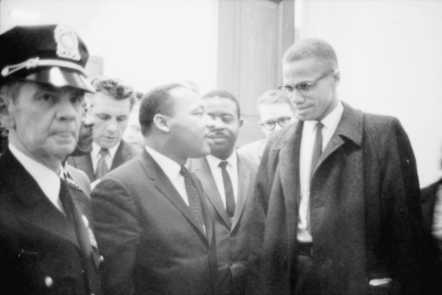 Martin Luther King Jr. and Malcolm X wait for a press conference to begin in an unknown location, March 26, 1964 (credit: CONGRESS/MARION S. TRIKOSKO/HANDOUT VIA REUTERS)