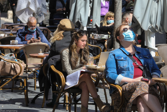 People sit and drink coffee in the sun as Israel reopens its economy after COVID-19 restrictions   (credit: MARC ISRAEL SELLEM)
