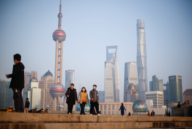 People walk at the Bund, in front of Lujiazui financial district of Pudong, Shanghai (credit: REUTERS/ALY SONG)