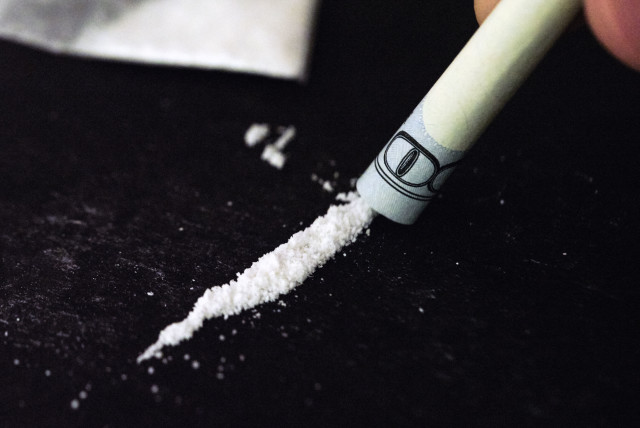 A line of cocaine is seen being snorted through a rolled up dollar. (credit: DANIEL FOSTER/FLICKR)