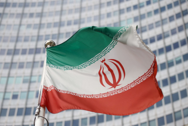 The Iranian flag waves in front of the International Atomic Energy Agency (IAEA) headquarters, before the beginning of a board of governors meeting, amid the coronavirus disease (COVID-19) outbreak in Vienna, Austria, March 1, 2021. (credit: REUTERS/LISI NIESNER/FILE PHOTO)