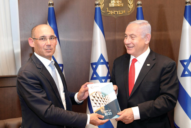 Bank of Israel Governor Prof. Amir Yaron presents the central bank’s Annual Report for 2020 to Prime Minister Benjamin Netanyahu on April 6. (credit: AMOS BEN-GERSHOM/GPO)