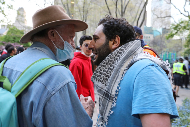 A pro-Palestinian demonstrator faces an Israel supporter during a protest in front of city hall in Toronto, Ontario, Canada May 15, 2021. (credit: CHRIS HELGREN/REUTERS)