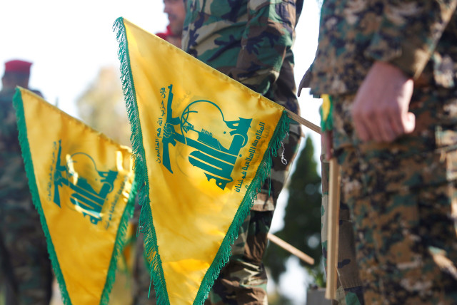 Hezbollah members hold flags marking Resistance and Liberation Day, in Kfar Kila near the border with Israel, southern Lebanon, May 25, 2021 (credit: REUTERS/AZIZ TAHER)