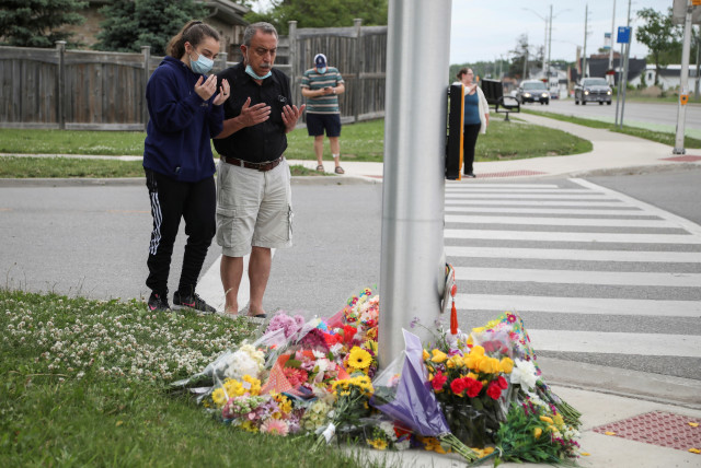 Abdullah Alzureiqi and his daughter Hala say a prayer at the fatal crime scene where a man driving a pickup truck jumped the curb and ran over a Muslim family in what police say was a deliberately targeted anti-Islamic hate crime, in London, Ontario, Canada June 7, 2021. (credit: CARLOS OSORIO/REUTERS)